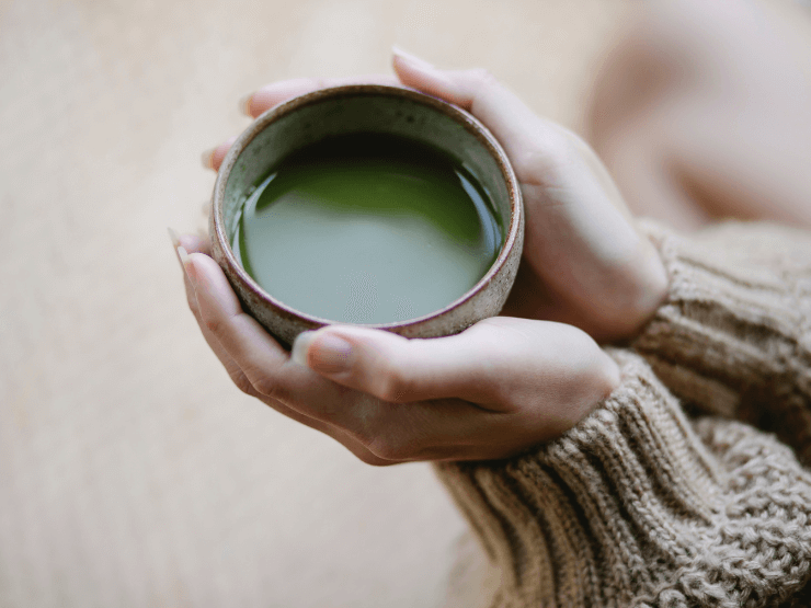 Primo piano di una donna che tiene la bevanda Matcha