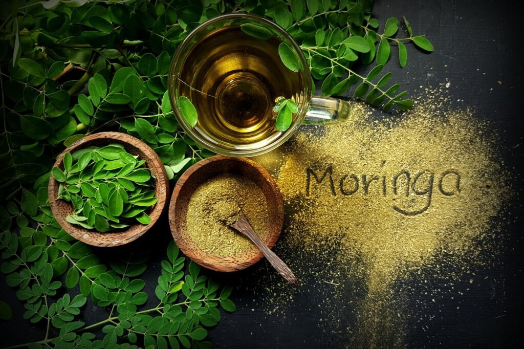 Tè moringa oleifere con polvere sul tavolo