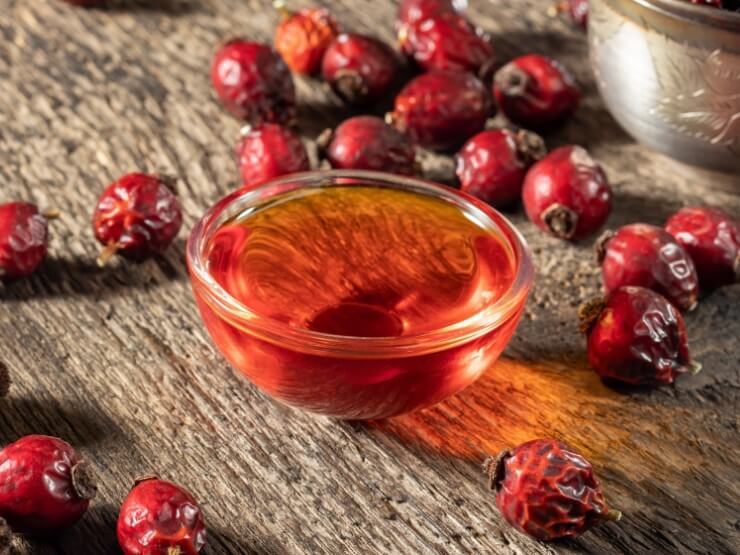 Una ciotola di olio di semi di rosa canina con cinorrodi essiccati